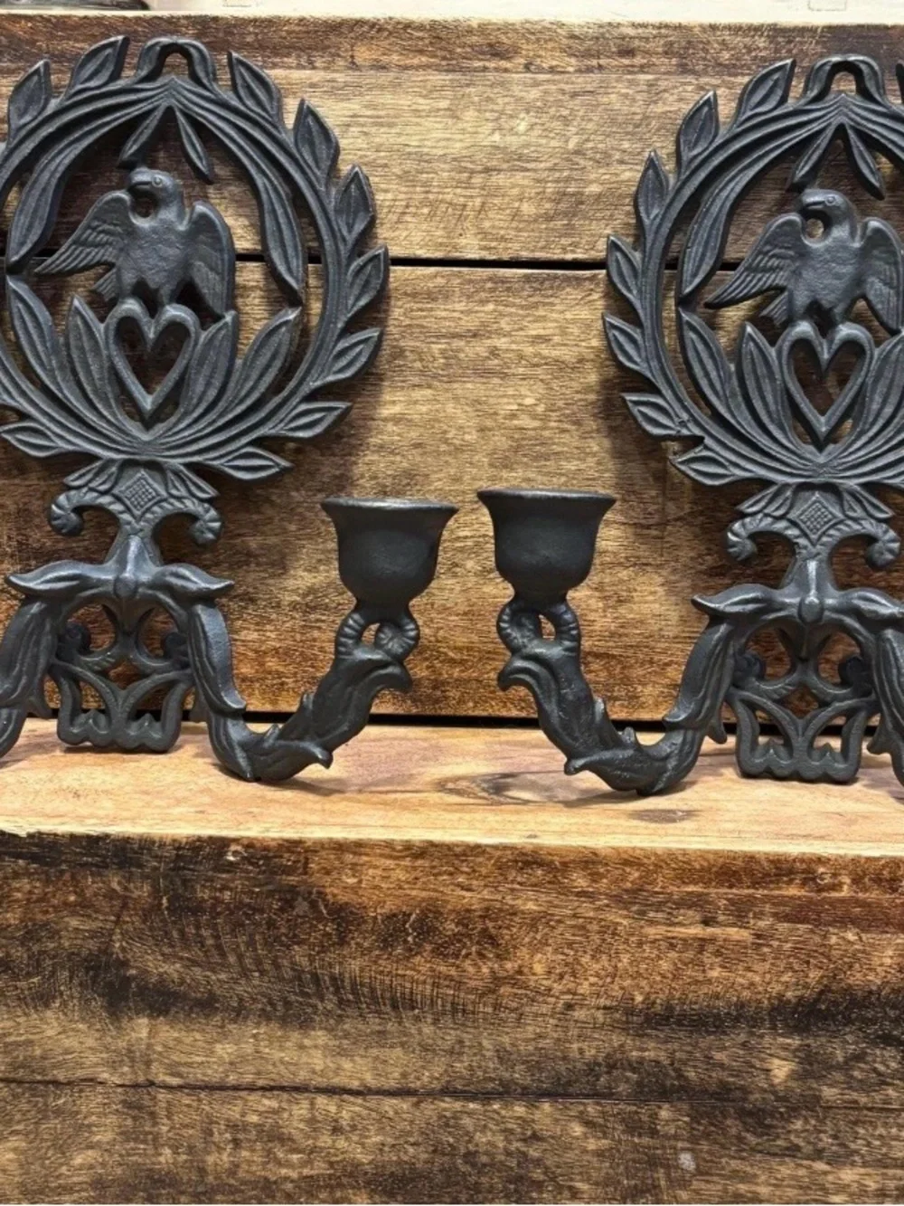 A pair of vintage cast iron wall sconces with eagle and laurel wreath motif